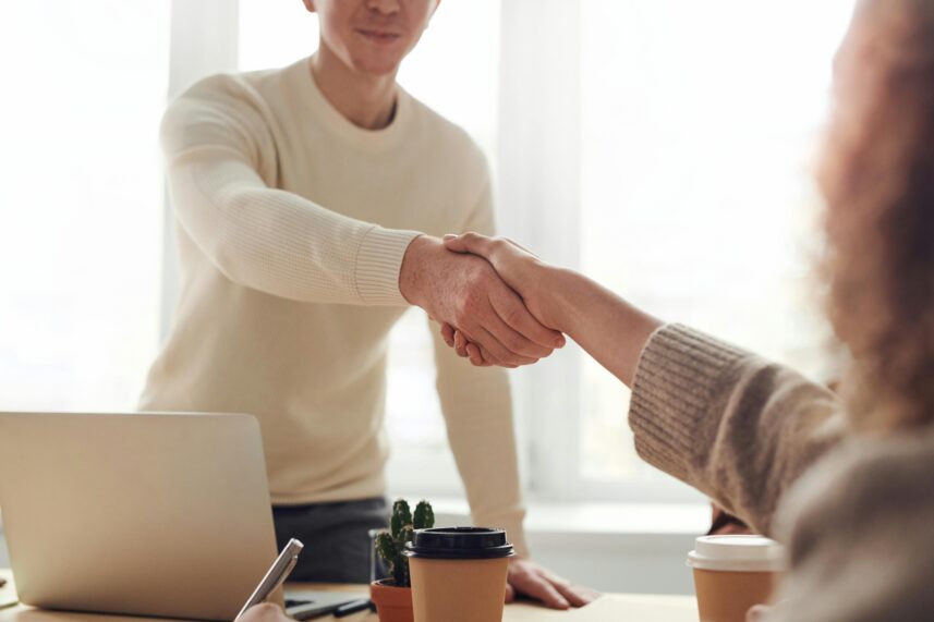 a man and woman shaking hands over a desk