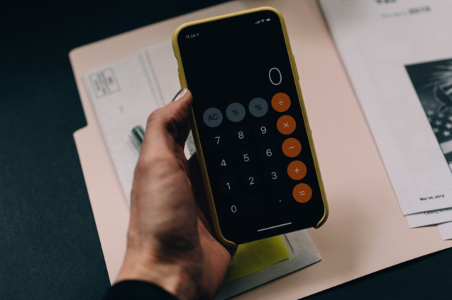 Image of mobile phone calculator and some papers indicating someone is budgeting.